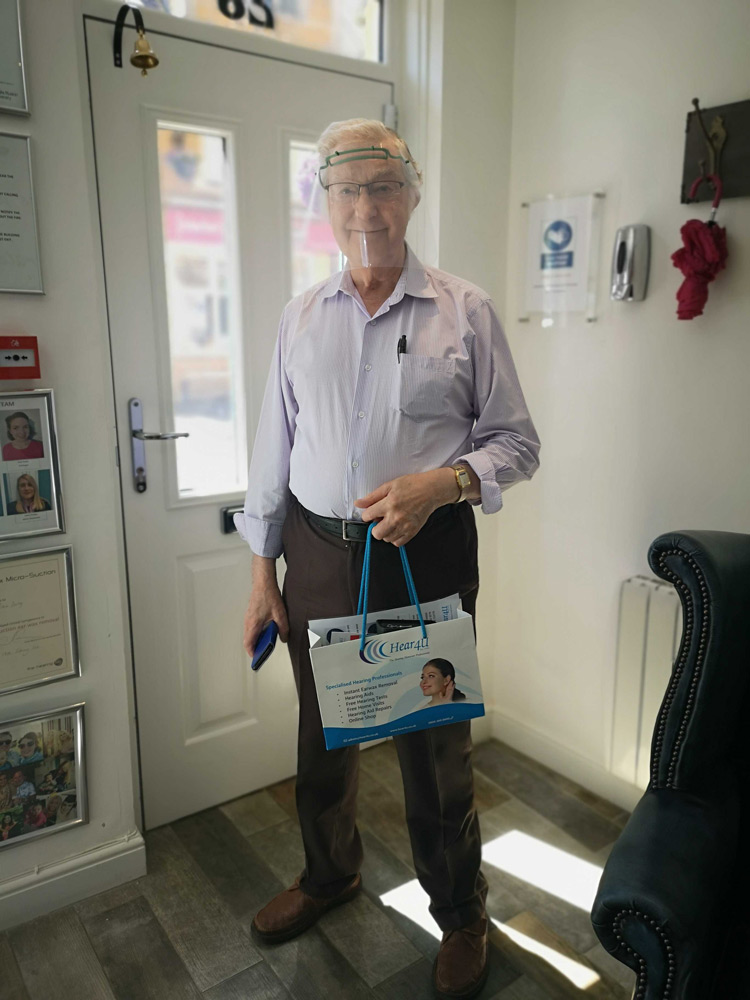 Veteran Standing with hearing aid bag infront of door
