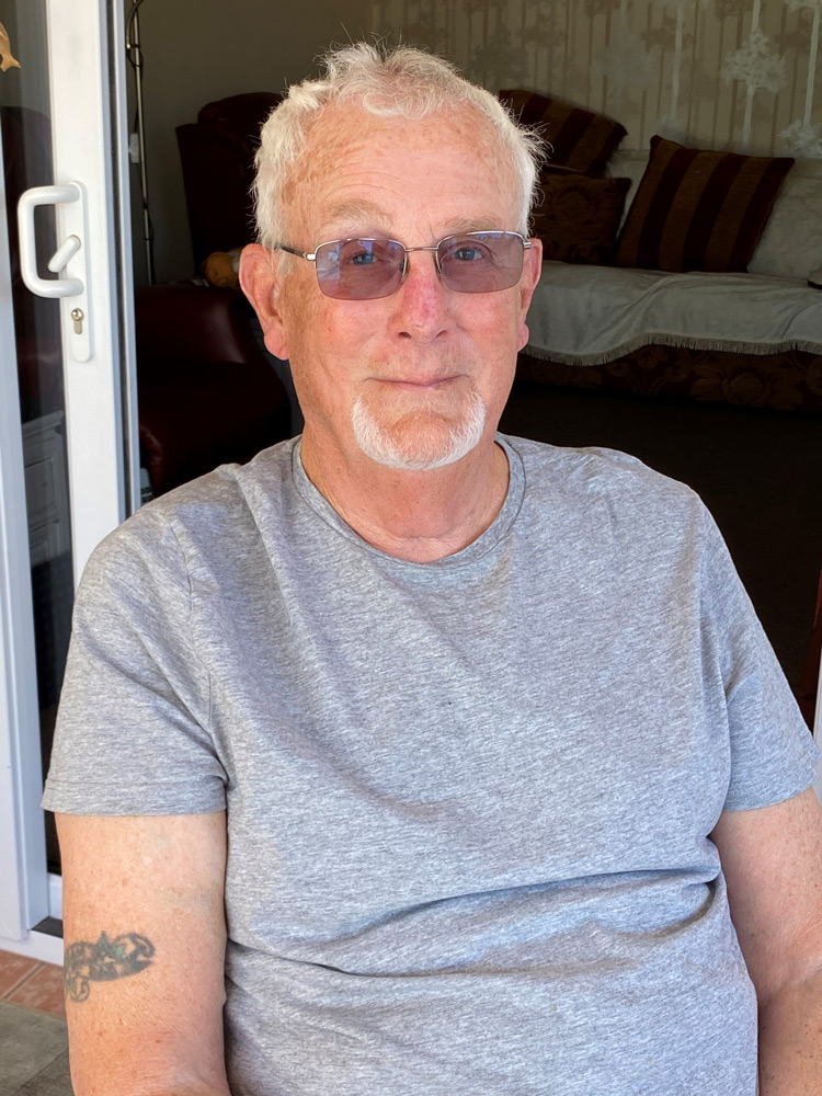 Photograph of man sitting on porch with glasses