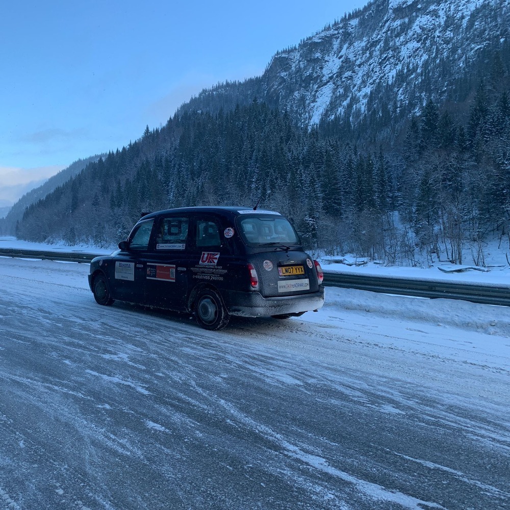 Taxi to Norway photo; taxi on icy road with trees and snow in background.